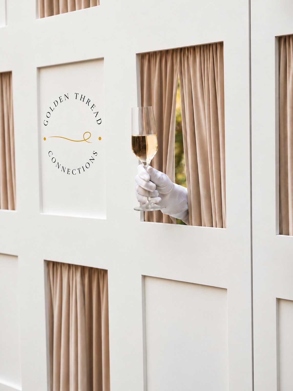 A branded Golden Thread Connections champagne wall, a gloved hand passing a filled glass through one of its windows